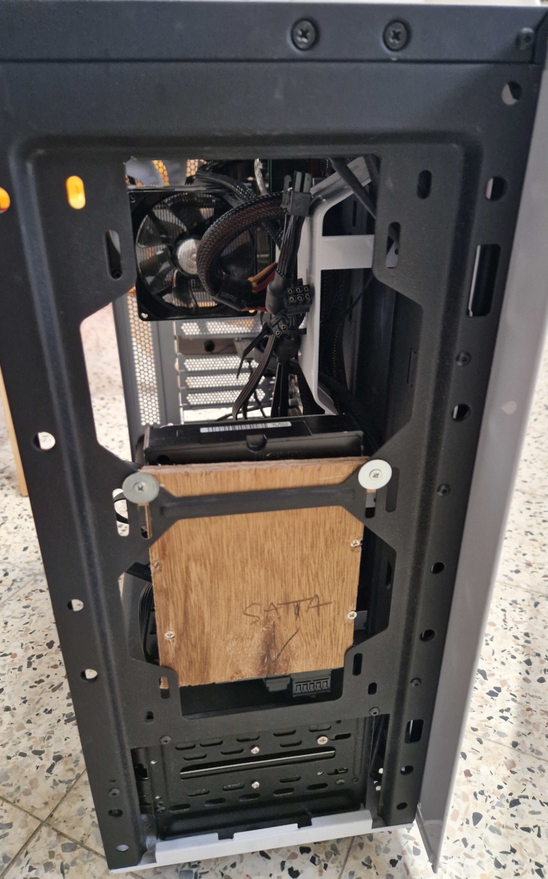 l'avant de la tour avec la planche vissée à l'intérieur sur l'emplacement du bas destiné aux ventilateurs