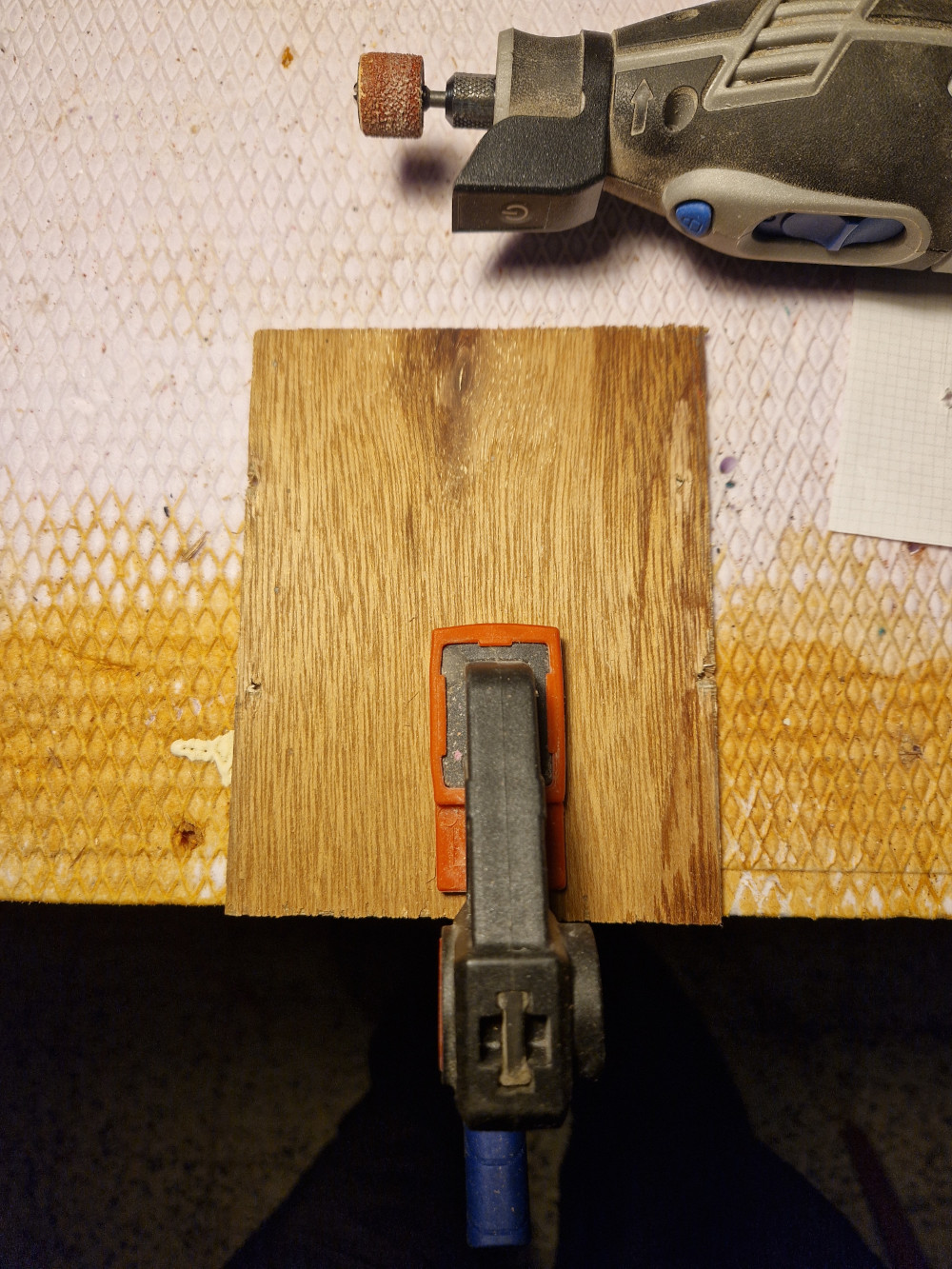 le recto de la plaque avec les trous polis et un Dremel sur la photo