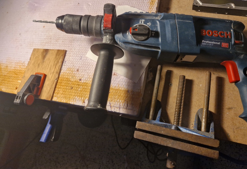 un gros perforateur pneumatique se tient à côté de la plaque