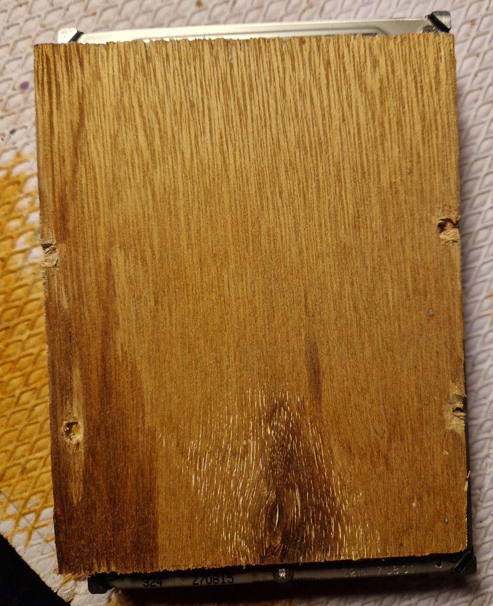 la plaque qui couvre bien l'arrière du disque dur avec les trous creusés davantage pour permettre l'insertion des vis