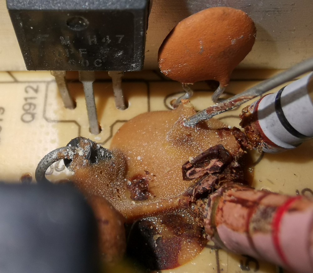 Zoom sur l'endroit avec la pâte brunâtre qui a l'air un peu brûlée ainsi que de la corrosion sur les conducteurs visibles