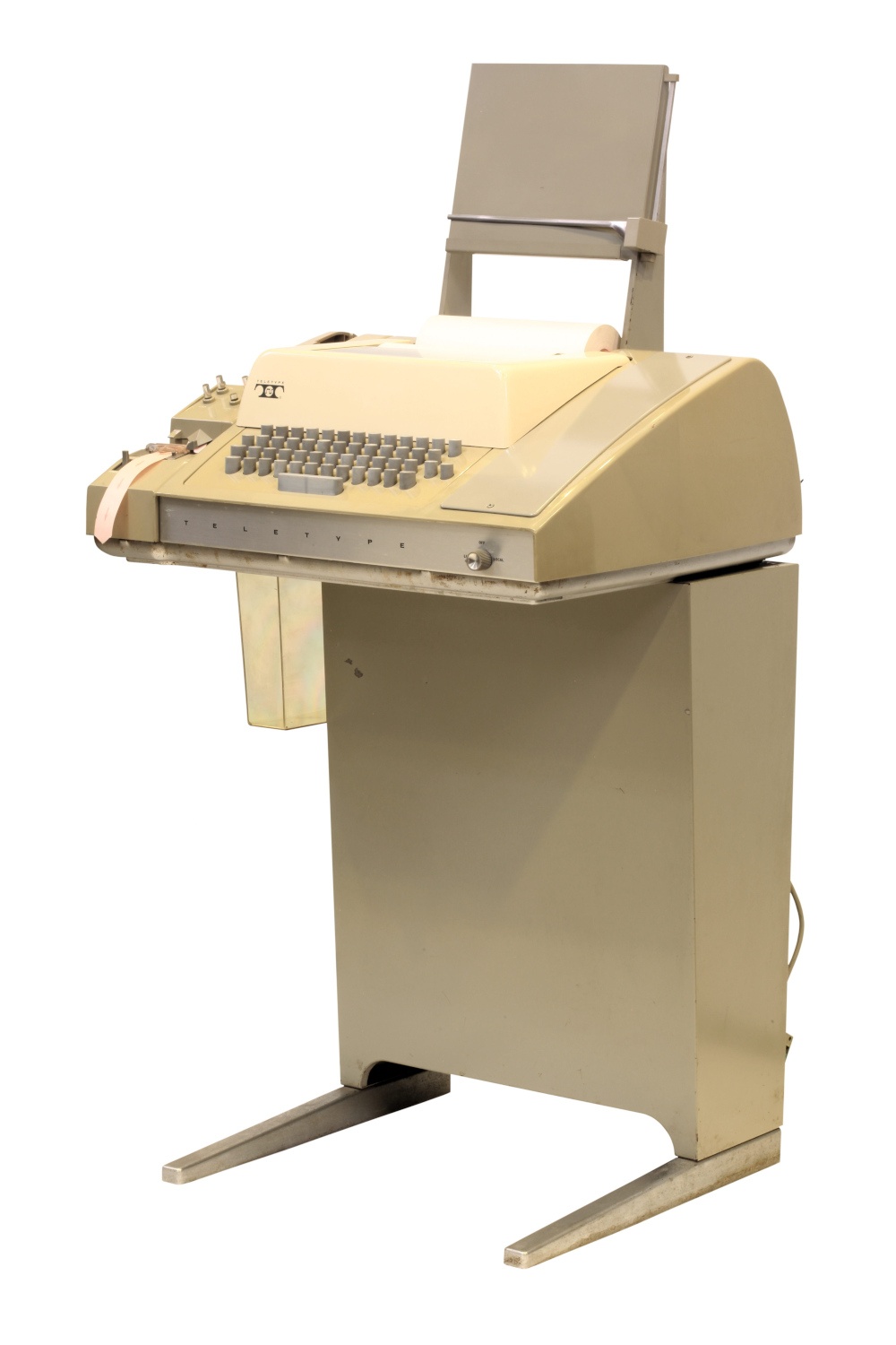 Une machine teletype blanc crème qui est en fait une table avec un gros clavier et un pupitre